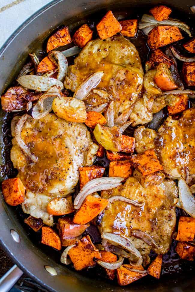 pork chops with veggies in a cast iron skillet.