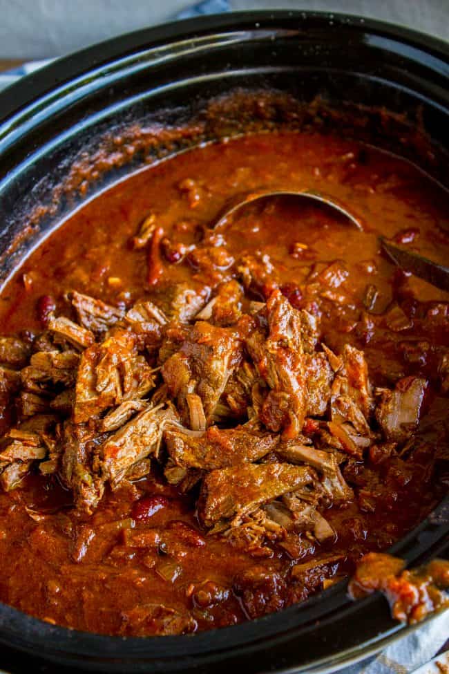 chili with shredded beef and kidney beans in crock pot with ladle.