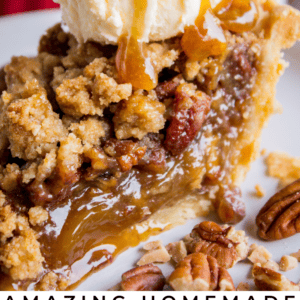 A close-up of a slice of pecan pie topped with vanilla ice cream and caramel sauce, with pecans scattered around. The text reads: Amazing Pecan Pie - The Food Charlatan.