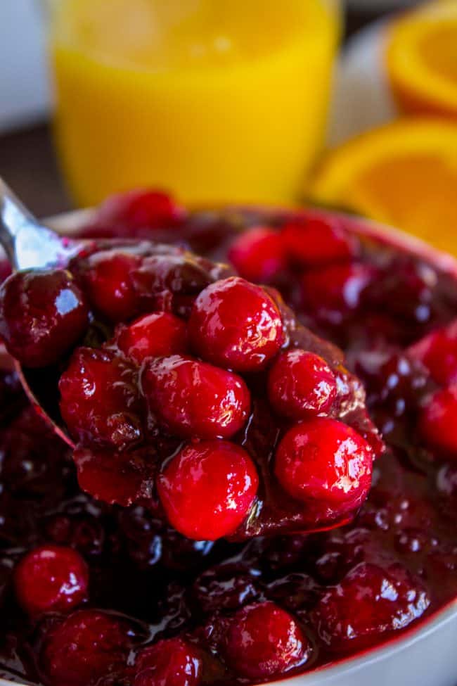 fresh cranberry sauce lifted by a spoon from a bowl.