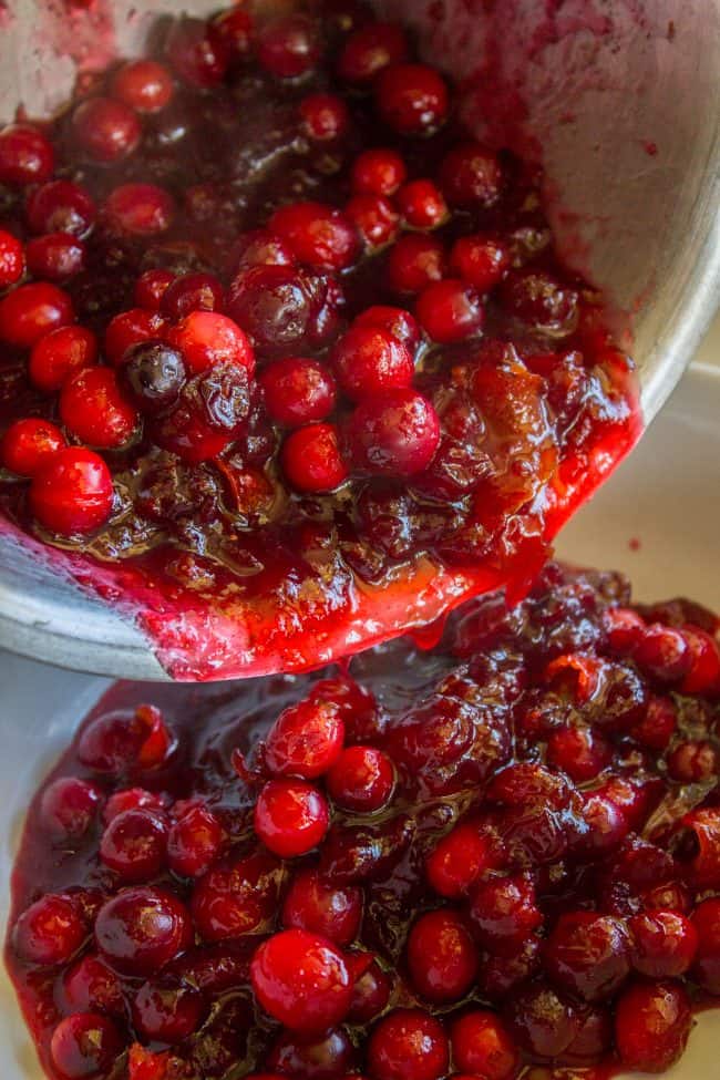 pouring homemade cranberry sauce into a bowl.