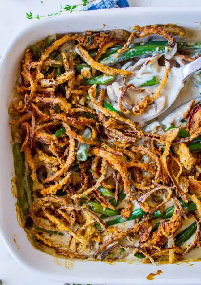 green bean casserole with homemade crispy fried onions and a serving spoon. 