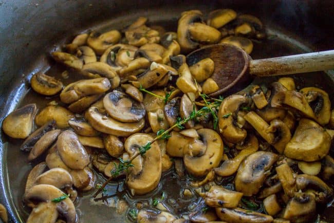 sauteeing mushrooms with fresh thyme.