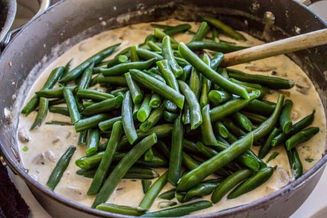 adding blanched green beans to creamy mushroom sauce. 