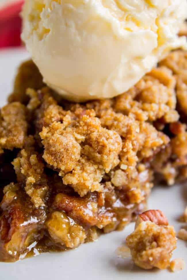 a slice of streusel topped pecan pie with vanilla ice cream.