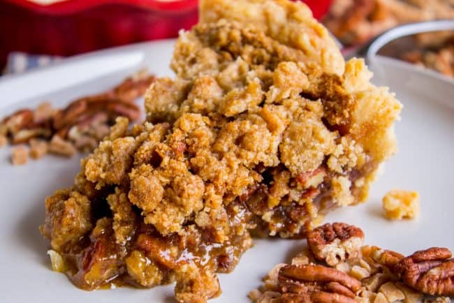 a slice of pecan pie on a plate with streusel topping.