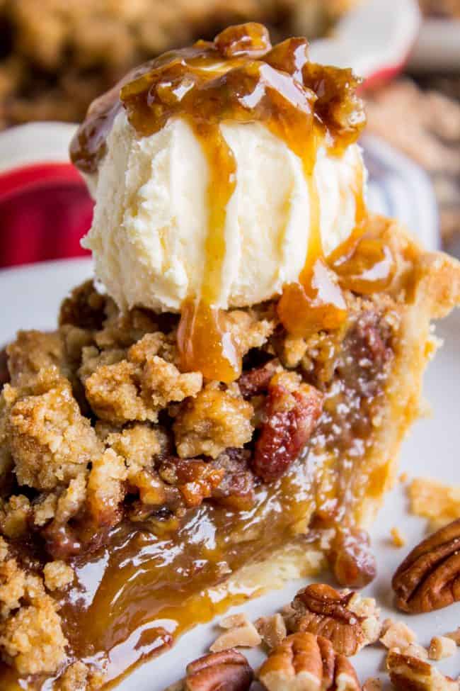 a slice of streusel topped pecan pie with vanilla ice cream and caramel sauce.