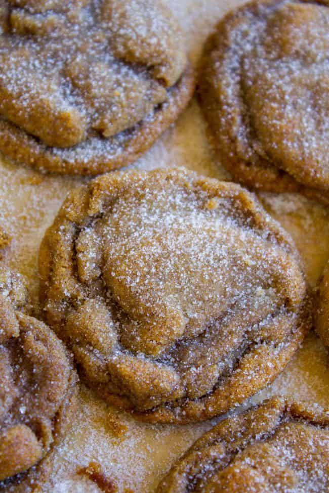 molasses cookies rolled in sugar on a parchment lined baking sheet.
