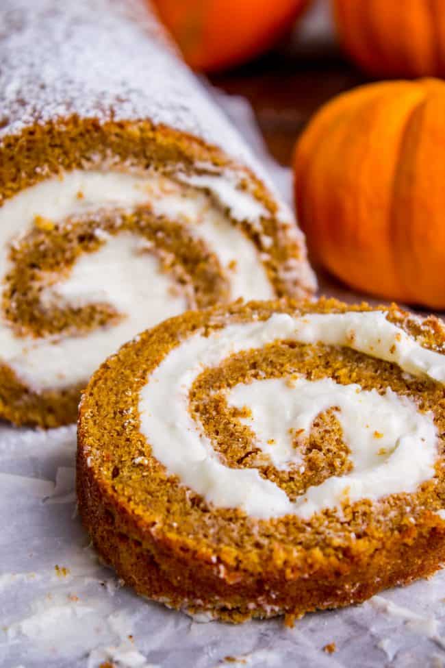 pumpkin roll with cream cheese frosting, with one slice cut. 