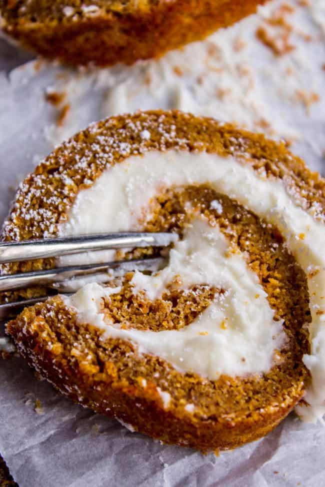 a slice of pumpkin roll with a fork in it. 
