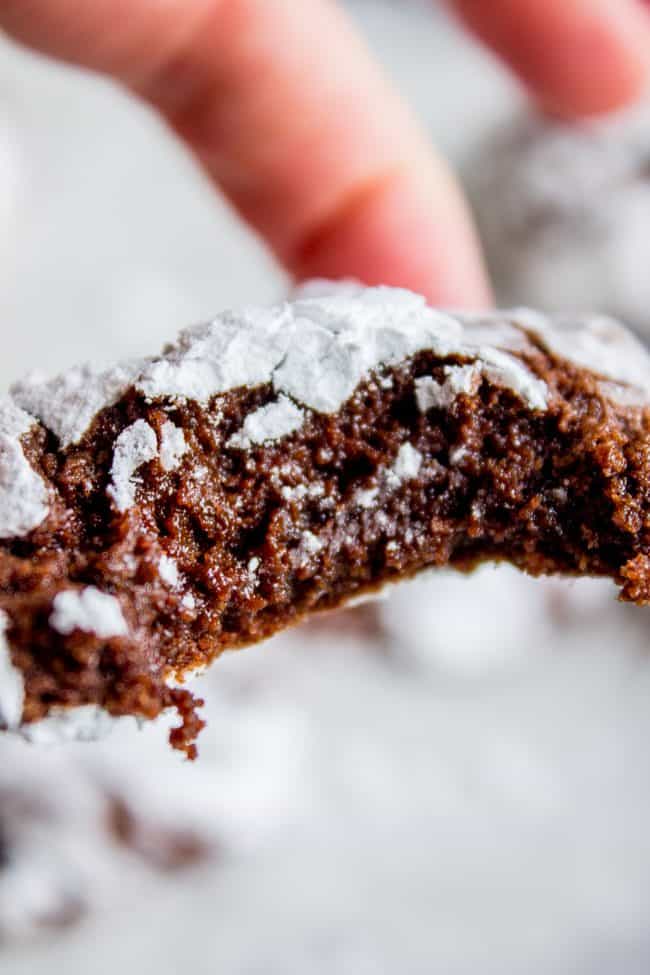 chocolate crinkle cookie with a bite taken out of it. 