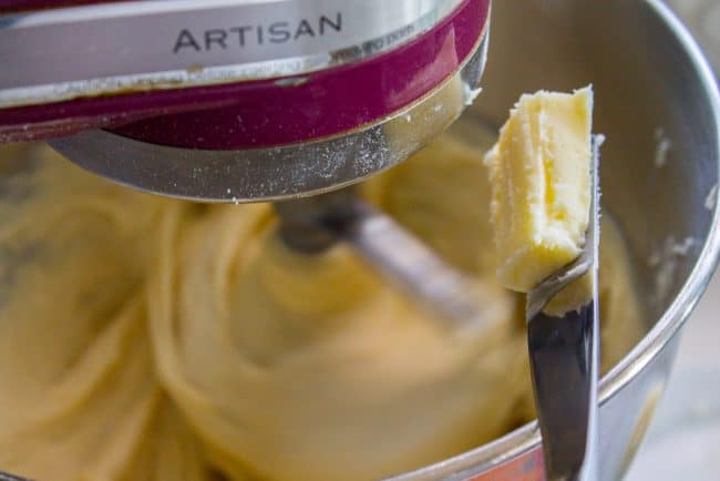 pecan sticky buns recipe showing butter on a knife being dropped into a stand mixer