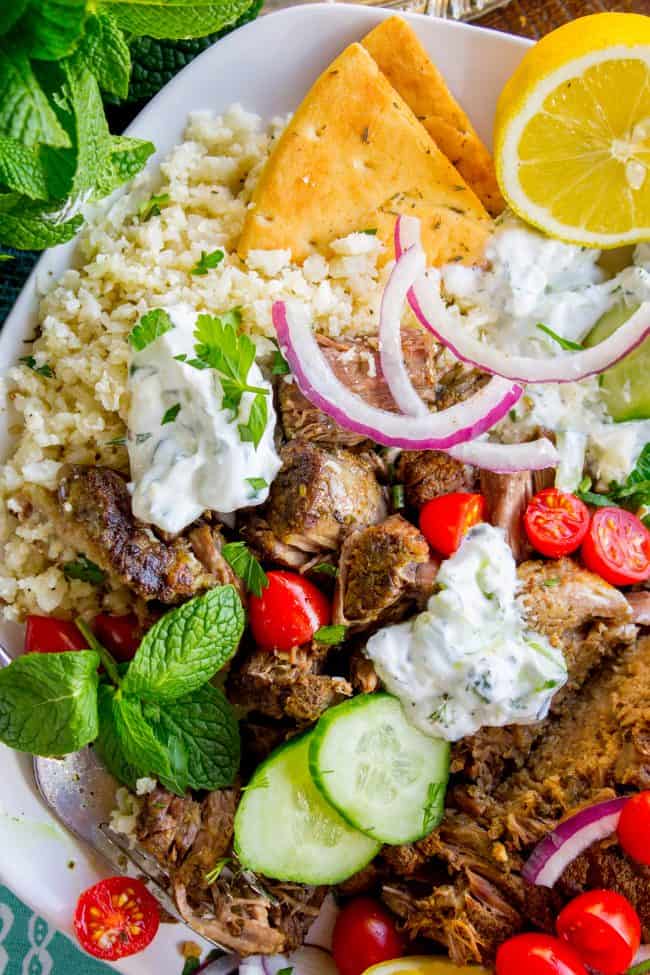 shredded gyro beef with cauliflower rice, tzatziki sauce, toasted pita bread, fresh veggies, and herbs.