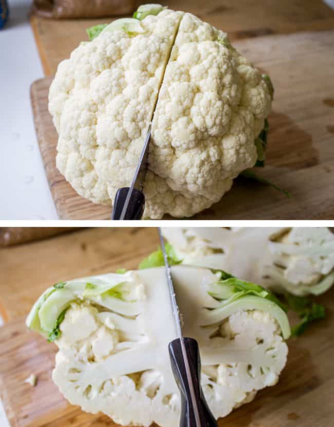 cutting a cauliflower in half on a wooden cutting board.