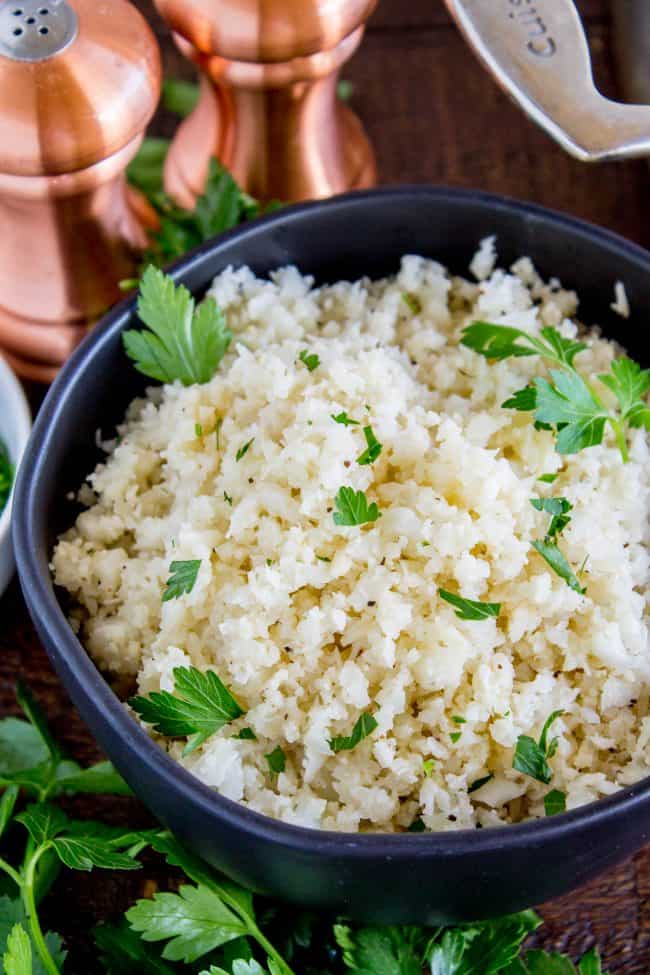 cauliflower rice garnished with cilantro in a black bowl. 