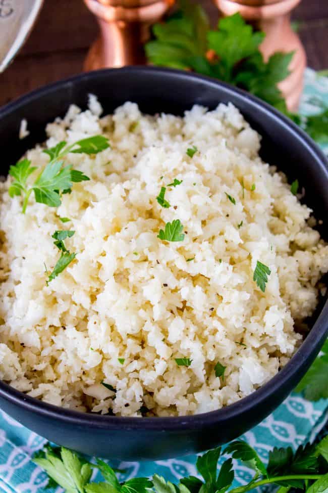 cauliflower rice garnished with cilantro in a black bowl.