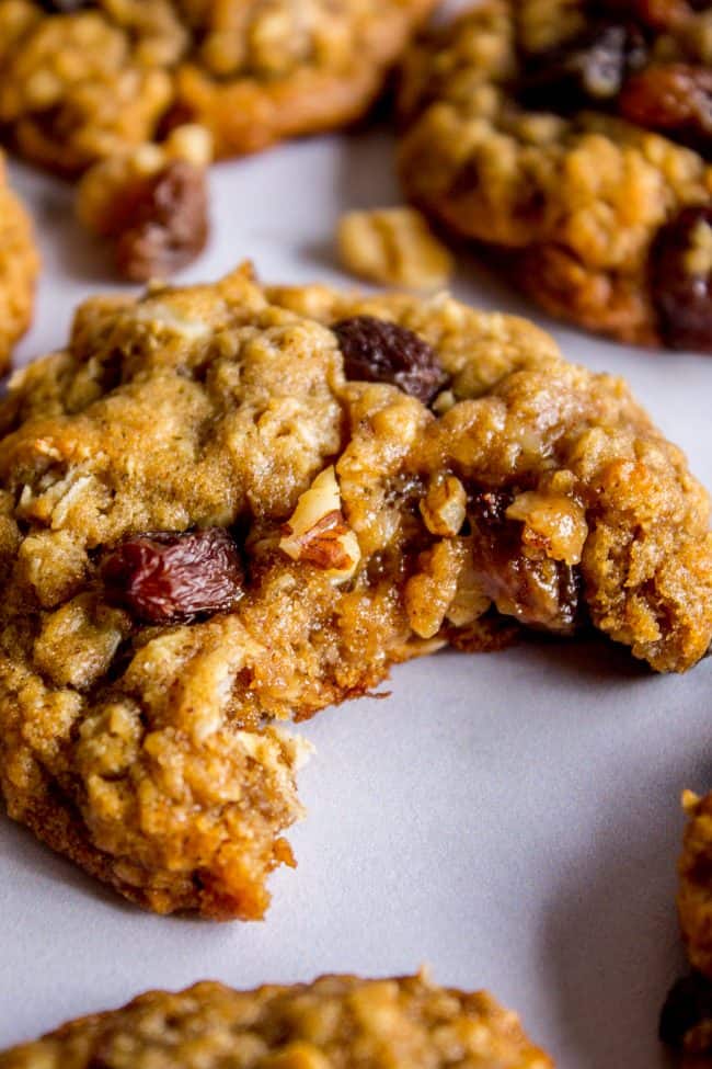 an oatmeal raisin cookie with a bite taken out of it on parchment paper.