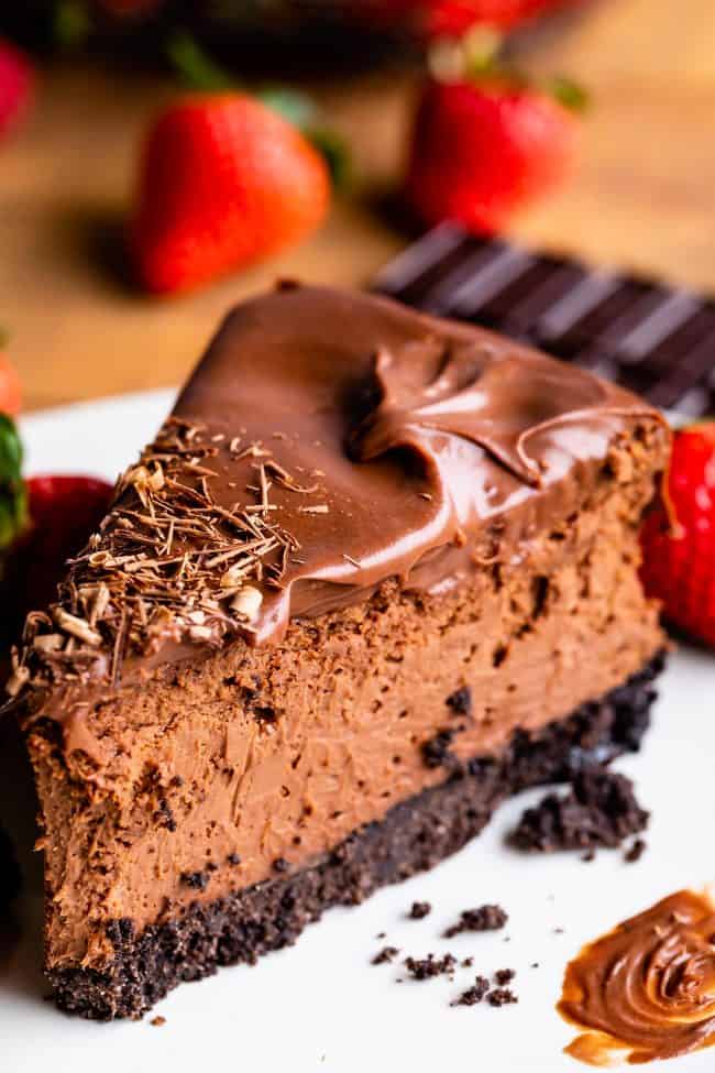 a slice of chocolate cheesecake topped with chocolate ganache.