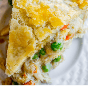 A close-up of a savory chicken pot pie with a golden double crust, filled with chicken, peas, and carrots, garnished with fresh thyme. Text reads: Classic Double Crust Chicken Pot Pie – The Food Charlatan.