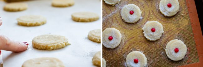 sugar cookies pressed flat on a baking sheet, sugar cookies with red hots pressed into the center.