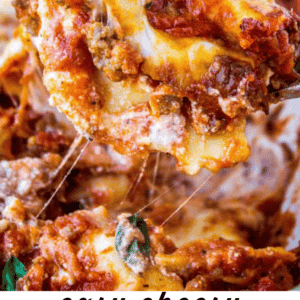 A close-up of a spoon lifting a cheesy, meaty slice of ravioli lasagna with melted cheese stretching above a dish. Text below reads: easy cheesy Ravioli Lasagna and The Food Charlatan. This mouthwatering twist uses ravioli for extra comfort.