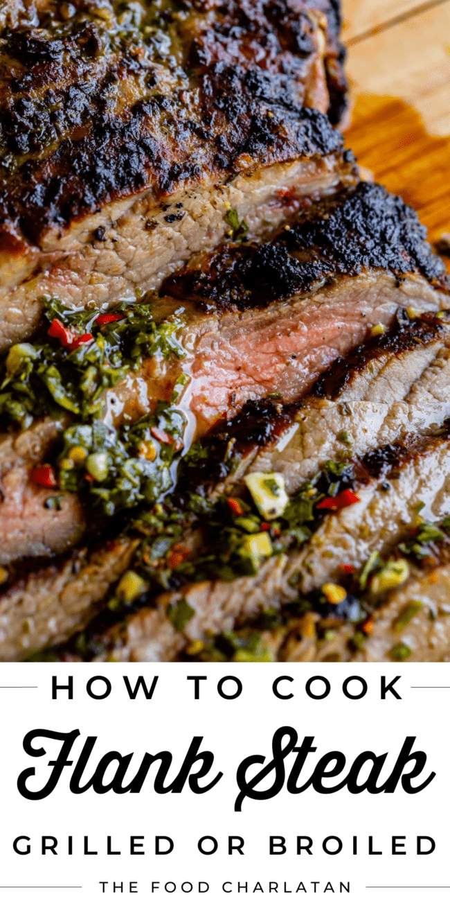 sliced flank steak on a wooden cutting board with chimichurri sauce.