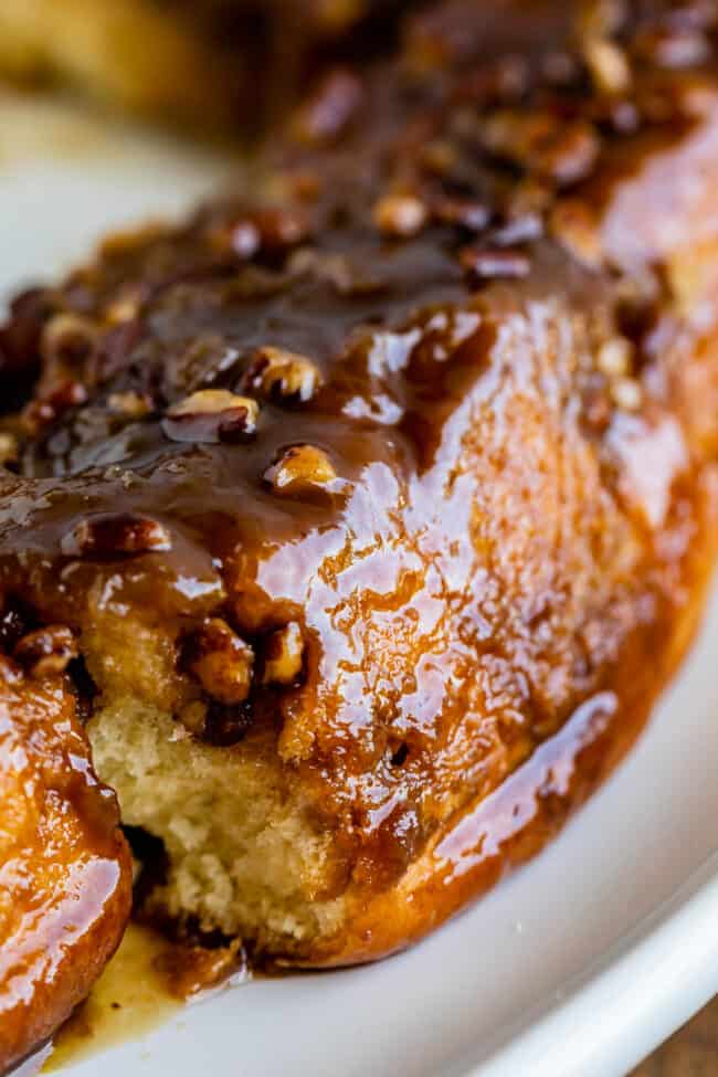 pecan cinnamon rolls with caramel sauce dripping over the side