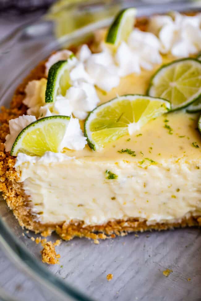 a key lime pie with whipped cream and lime slices.