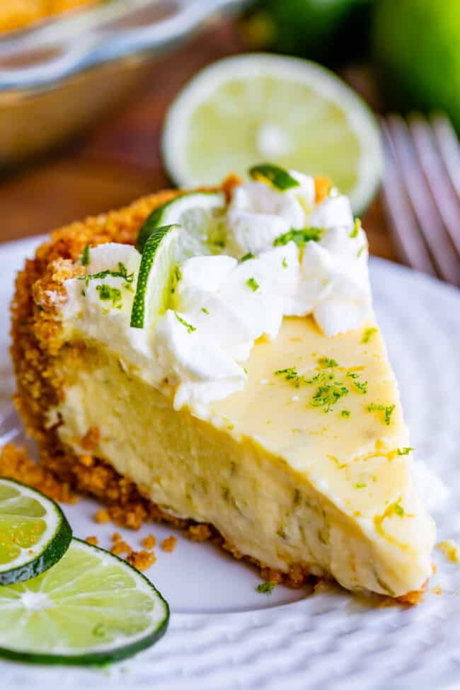 a slice of key lime pie with whipped cream and lime slices.