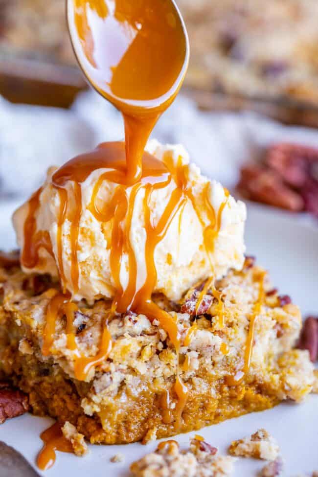 how to make pumpkin dump cake showing assembling ice cream over a slice of cake and drizzled with caramel sauce