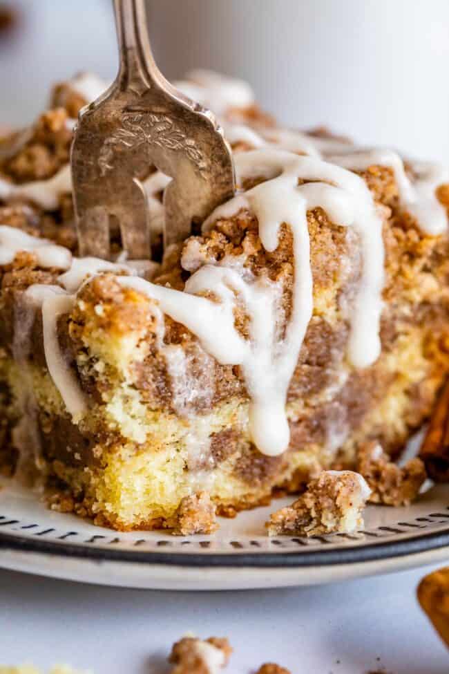 cinnamon streusel coffee cake on a plate with a fork stuck in it.