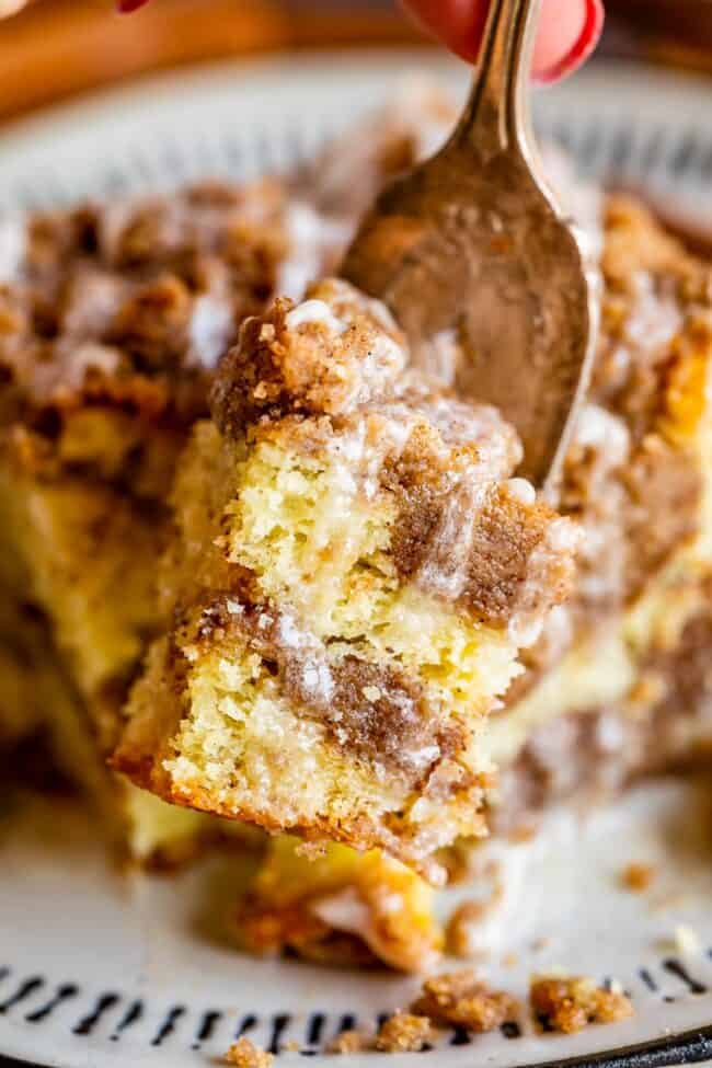 Slice of coffee cake with streusel and glaze on a fork.