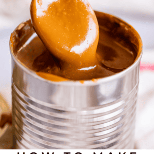 A spoon holding thick, creamy dulce de leche is lifted from an open tin can. Text below reads, Classic Dulce de Leche - The Food Charlatan.