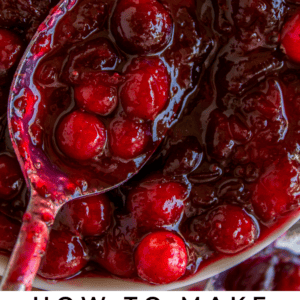 Close-up of a spoon scooping tangy cranberry sauce with whole cranberries in a thick, glossy red syrup; text below reads “How to Make Cranberry Sauce – The Food Charlatan.”.
