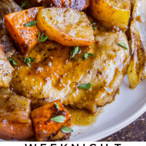 Glazed pork chops topped with herbs, served alongside roasted apples, sweet potatoes, and onions. Finished with fresh thyme. Text below reads: Weeknight Glazed Pork Chops with Apples & Sweet Potatoes.