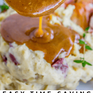 A close-up of brown gravy poured over creamy mashed potatoes with herbs and bits of red potato skin, with text below reading Easy Time-Saving Classic Turkey Gravy - The Food Charlatan. Perfect for holiday meals.