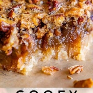 A close-up of gooey pecan pie bars topped with pecans and toffee, featuring a moist, caramelized filling and a soft crust. Text below reads: Gooey Pecan Pie Bars with Toffee.