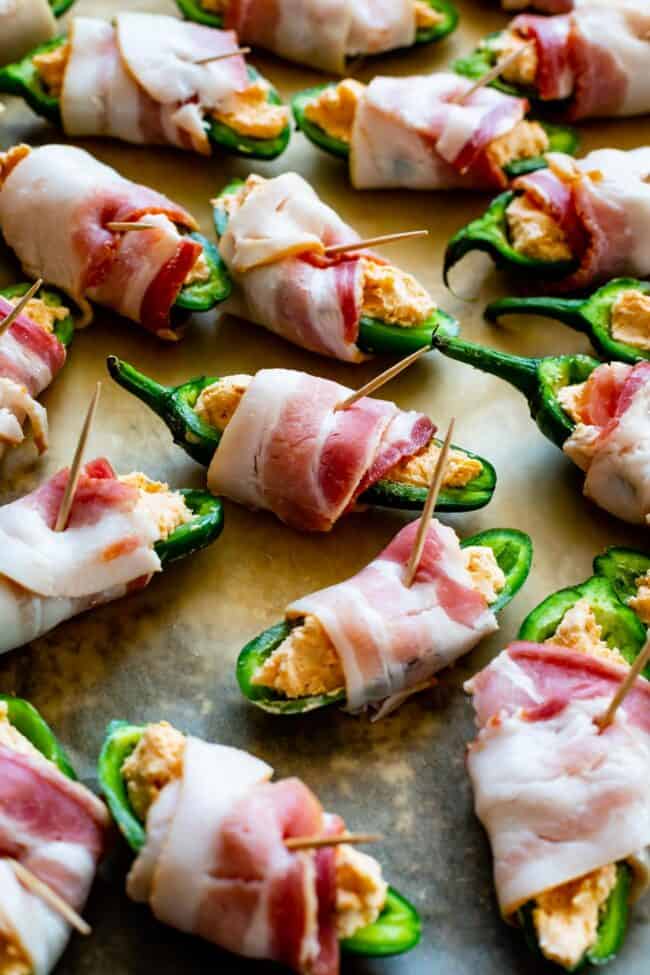 unbaked jalapeno poppers wrapped in bacon, secured with a toothpick.