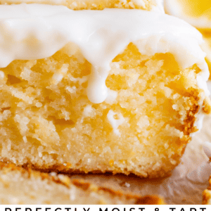 Close-up of a moist lemon bread loaf topped with glossy white glaze and fresh lemon slices. Text below reads: Perfectly Moist & Tart Glazed Lemon Bread from The Food Charlatan—full of bright, zesty flavor.
