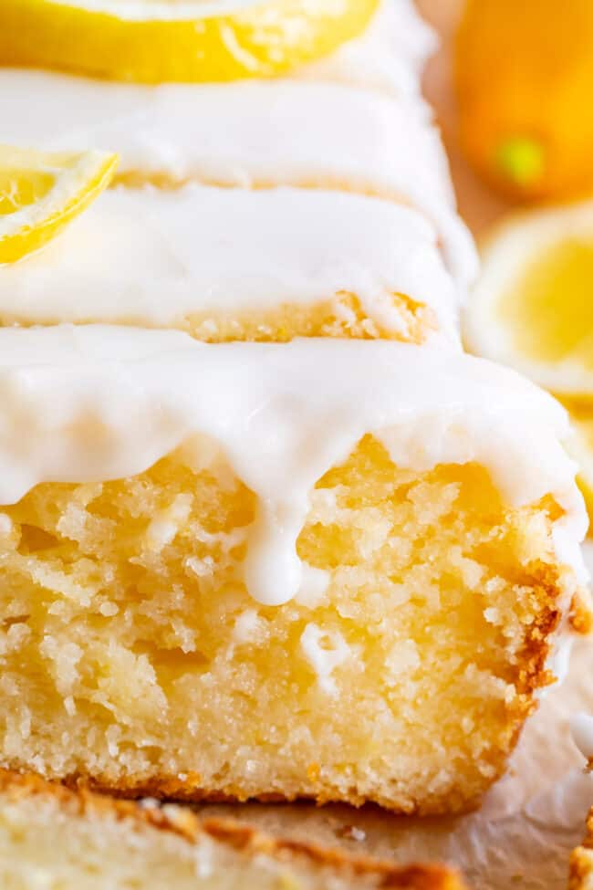 a loaf of glazed lemon quick bread that has been sliced.