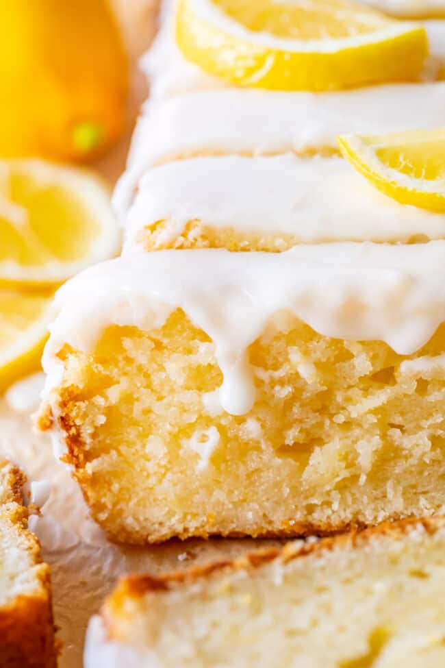 lemon loaf with glaze and fresh lemon slices.