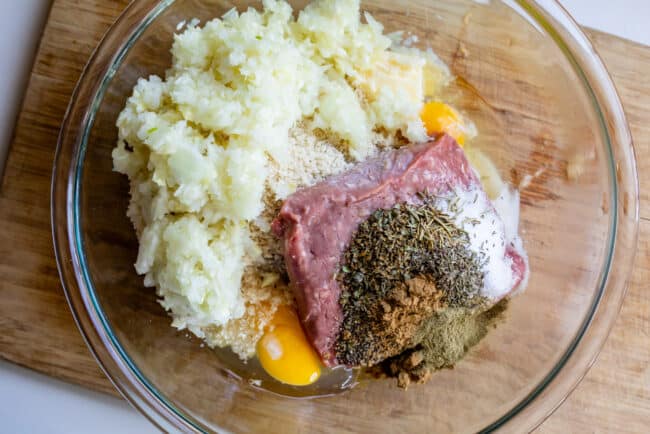 ground pork meat ingredients in a bowl on a cutting board.