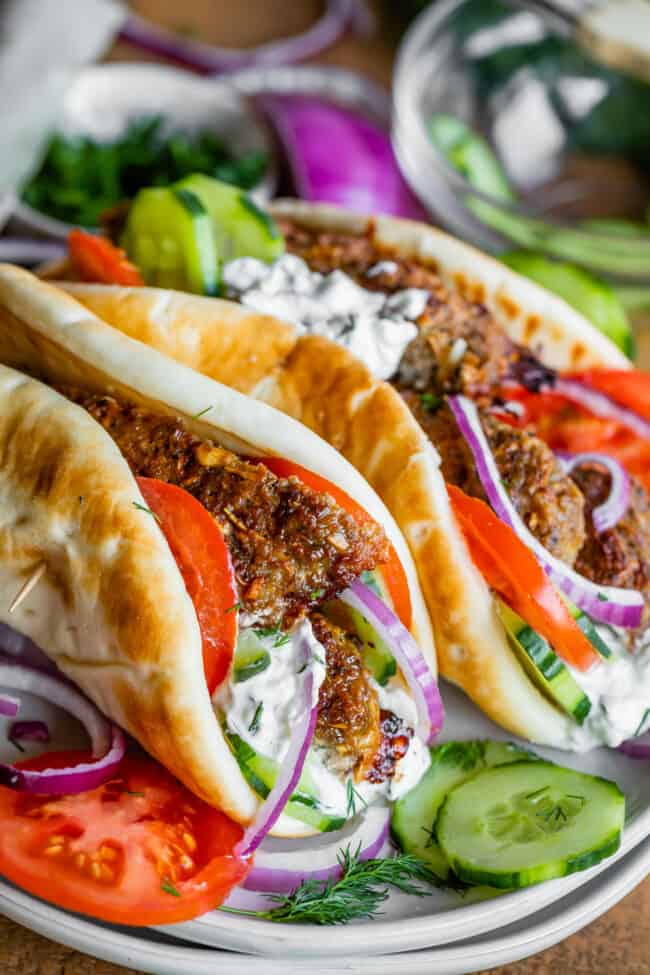 gyros with Greek gyro meat, tzatziki sauce, fresh dill, cucumbers, tomato, and red onion in pitas. 