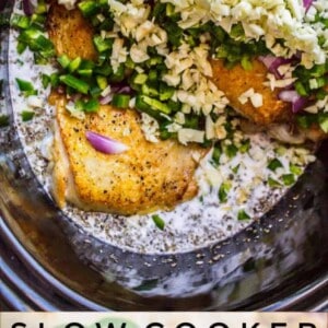 Raw ingredients for coconut curry chicken, such as chopped red onions, green herbs, and minced garlic, are layered over seasoned chicken in a pot. Text below describes this fragrant basil chicken slow-cooked in creamy coconut curry sauce.