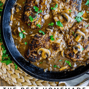 salisbury steak with mushroom gravy in a cast iron skillet.