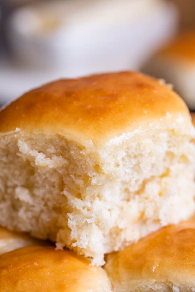 a fluffy homemade dinner roll on top of more dinner rolls. 