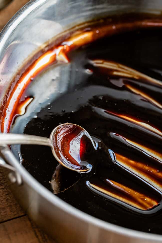 making a balsamic vinegar reduction in a pan with a metal spoon. 