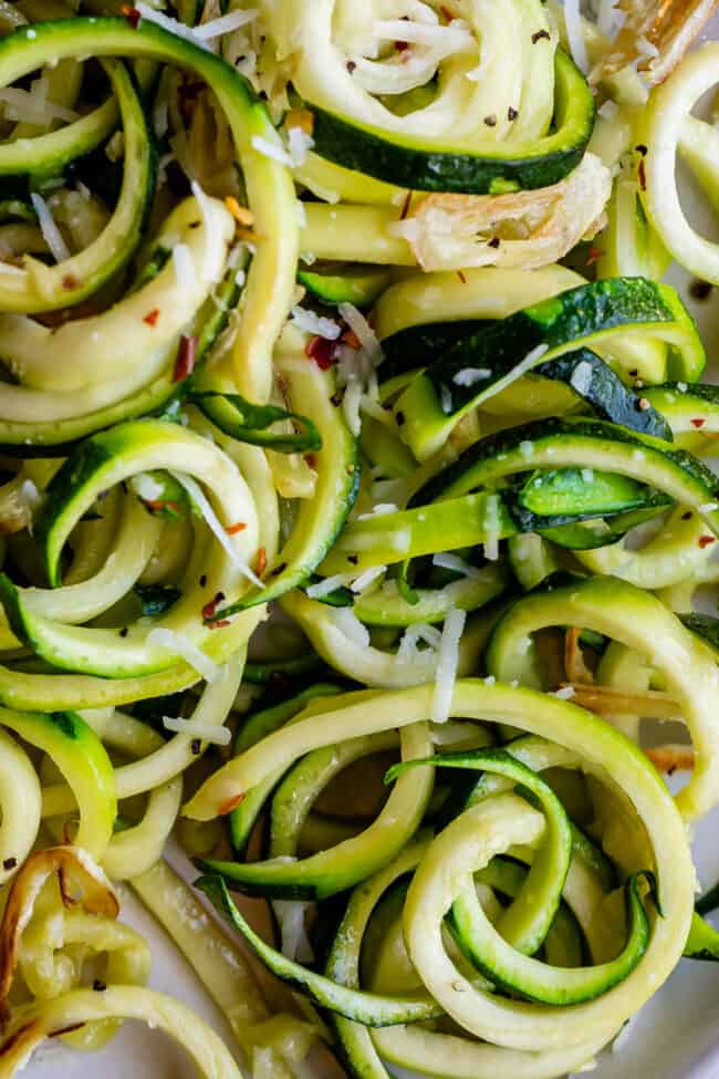 close up shot of curly zoodles with cheese.