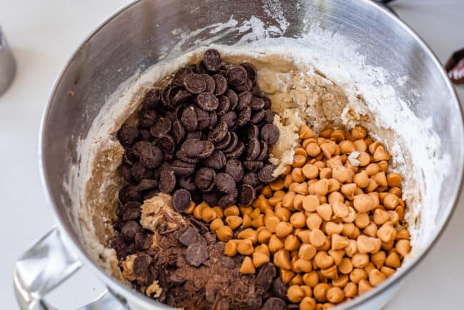 mixing dark chocolate and butterscotch chips into peanut butter cookie dough. 