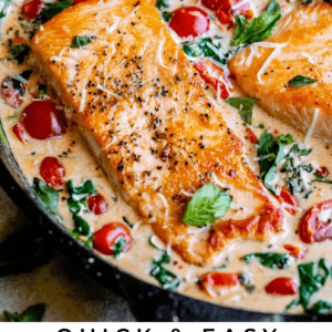 Salmon fillets in a creamy skillet sauce with cherry tomatoes, fresh basil, and spinach. Text overlay reads: Quick & Easy Creamy Tuscan Salmon. The Food Charlatan. Enjoy a vibrant Italian-inspired meal.